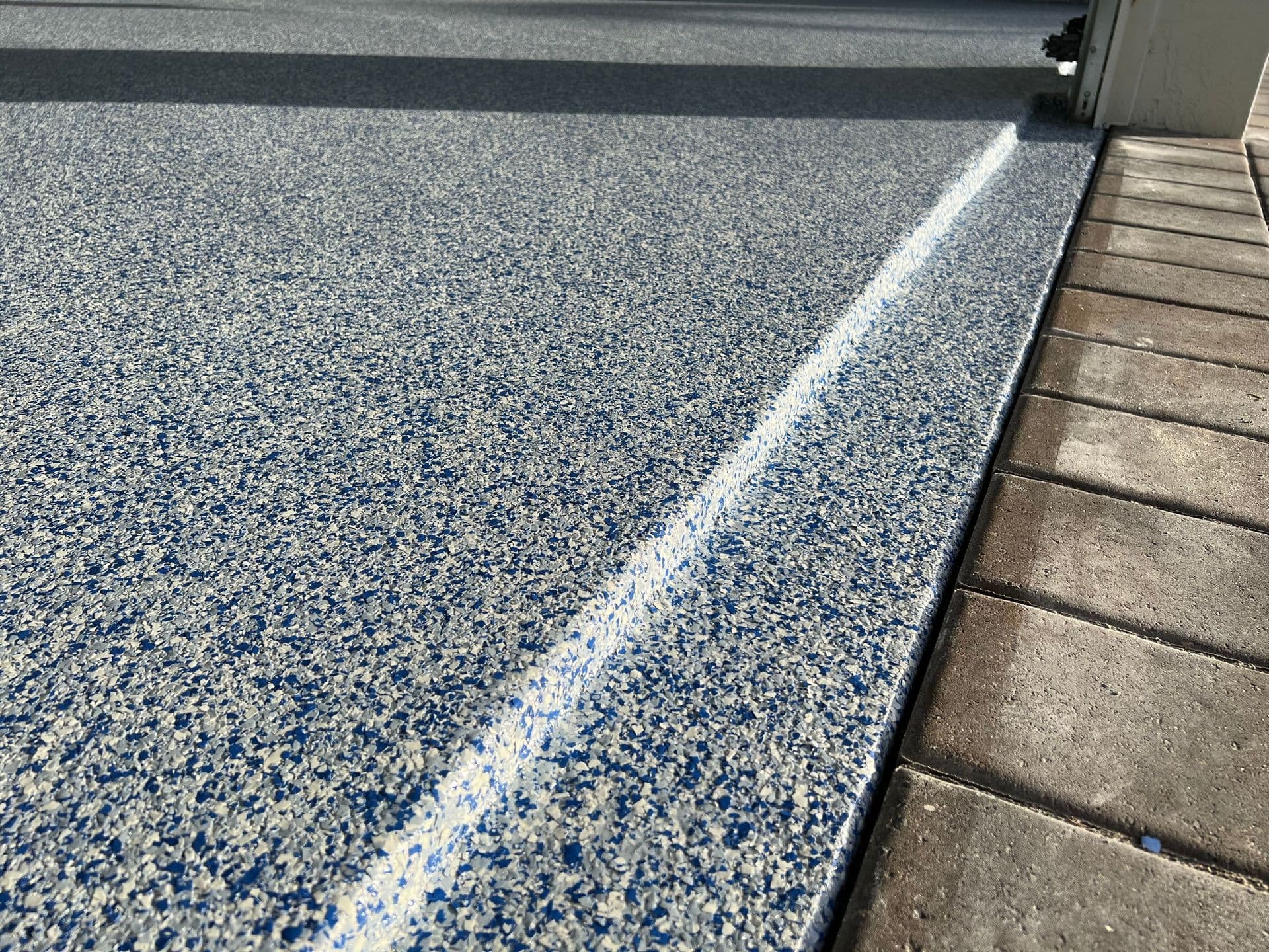 A full-coverage gray flake coating protecting a concrete garage slab in Fort Myers from wear and damage