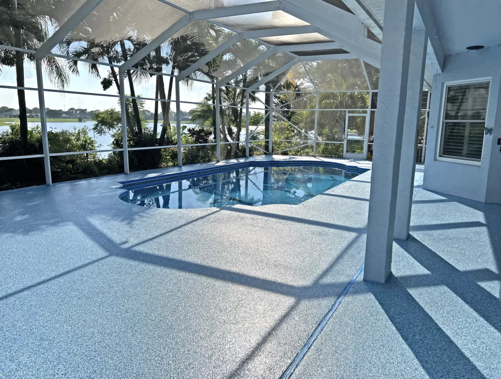 A pool deck with a vinyl floor, in the background we have a lake and a green area.