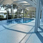 A pool deck with a vinyl floor, in the background we have a lake and a green area.